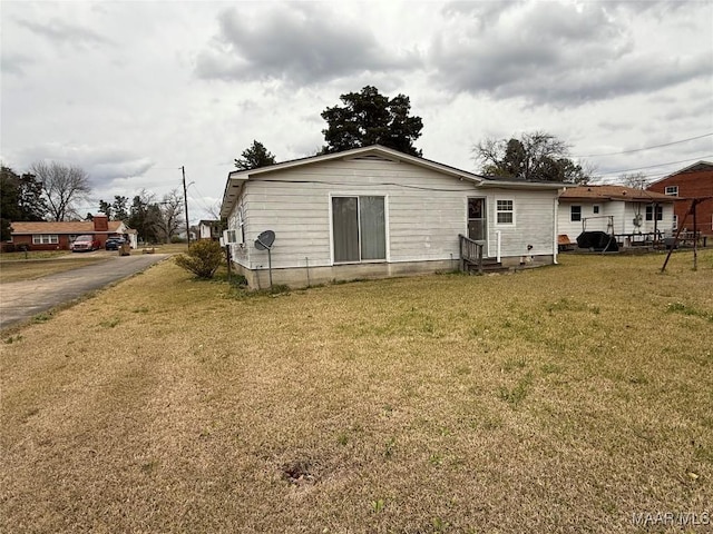 rear view of house with entry steps, cooling unit, a yard, and fence