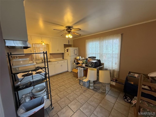 kitchen featuring ceiling fan, light tile patterned floors, white cabinetry, ornamental molding, and freestanding refrigerator