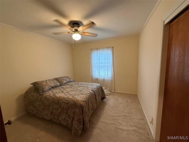 bedroom with carpet floors, crown molding, baseboards, and a ceiling fan