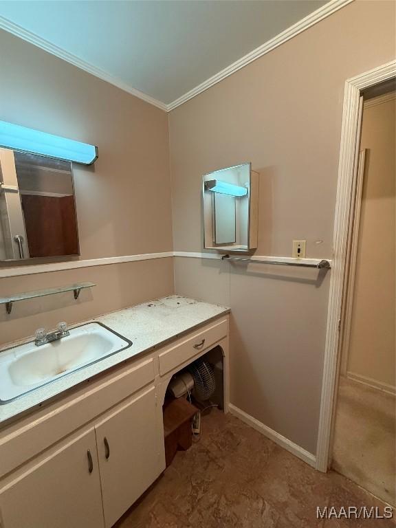 bathroom with baseboards, vanity, and crown molding