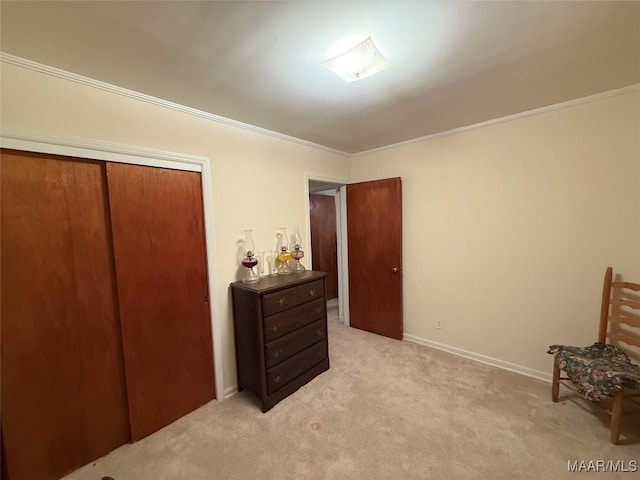 bedroom featuring a closet, baseboards, crown molding, and light colored carpet