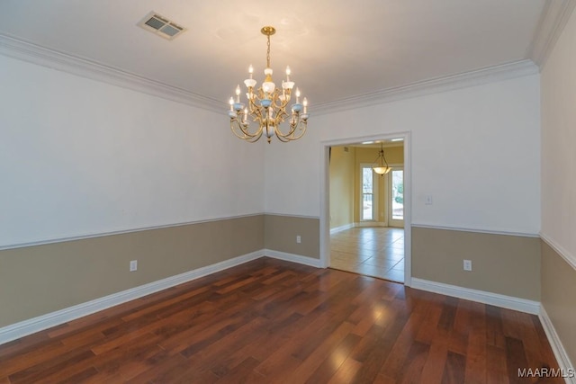 spare room featuring visible vents, crown molding, baseboards, and wood finished floors