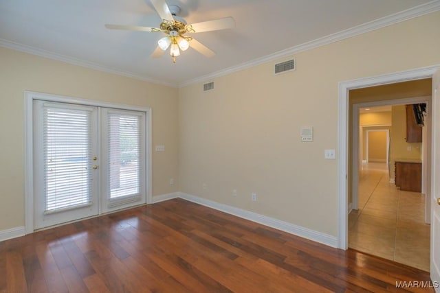 spare room featuring ornamental molding, visible vents, baseboards, and hardwood / wood-style flooring