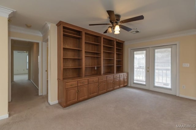 interior space featuring french doors, light colored carpet, visible vents, and crown molding