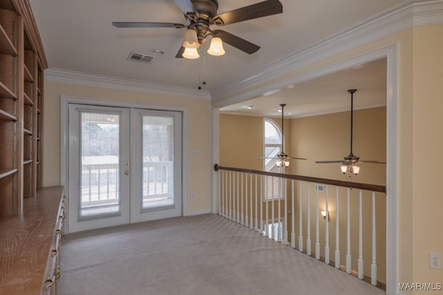 carpeted spare room with french doors, visible vents, and crown molding