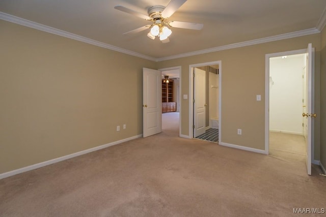 unfurnished bedroom featuring a walk in closet, ensuite bathroom, ornamental molding, carpet flooring, and baseboards