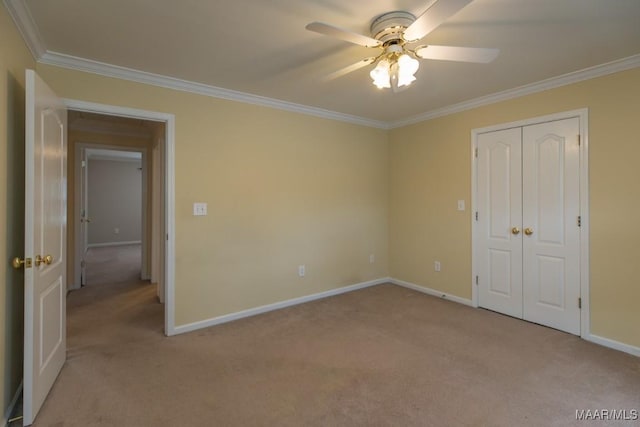 unfurnished bedroom featuring ceiling fan, light colored carpet, baseboards, a closet, and crown molding