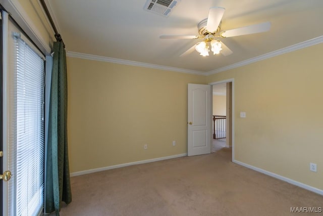 spare room with baseboards, visible vents, ceiling fan, crown molding, and carpet floors