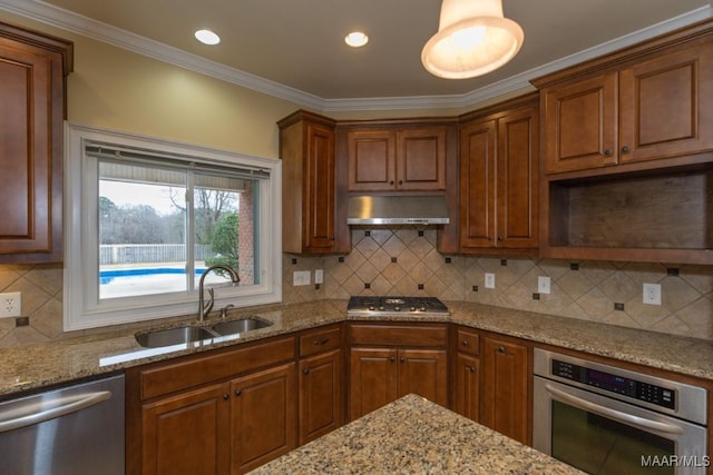 kitchen featuring under cabinet range hood, a sink, ornamental molding, appliances with stainless steel finishes, and light stone countertops