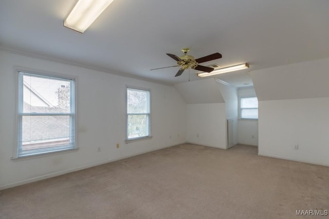 additional living space with light colored carpet, a ceiling fan, baseboards, vaulted ceiling, and visible vents