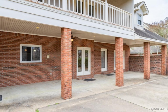 view of patio with french doors, ceiling fan, and a balcony