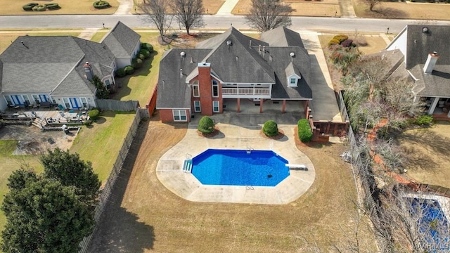 outdoor pool with a fenced backyard, a diving board, and a patio