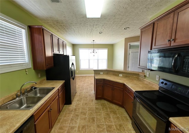 kitchen featuring a peninsula, a sink, black appliances, light countertops, and pendant lighting