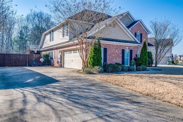 view of front of property featuring a garage, concrete driveway, brick siding, and fence