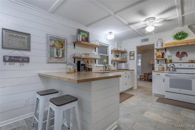 kitchen with a breakfast bar, open shelves, visible vents, wood counters, and white appliances