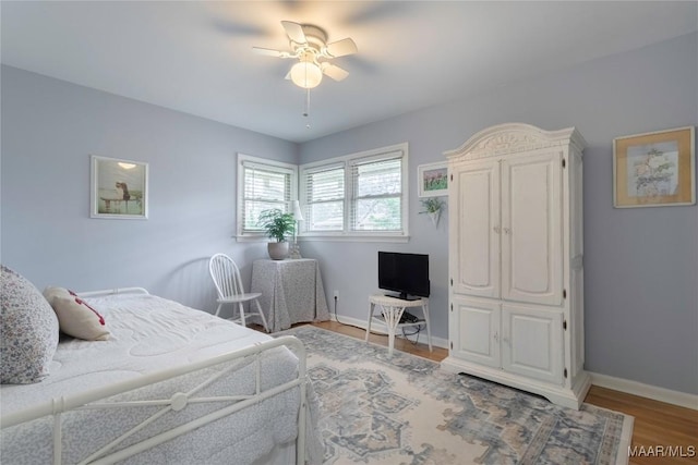 bedroom with ceiling fan, baseboards, and wood finished floors