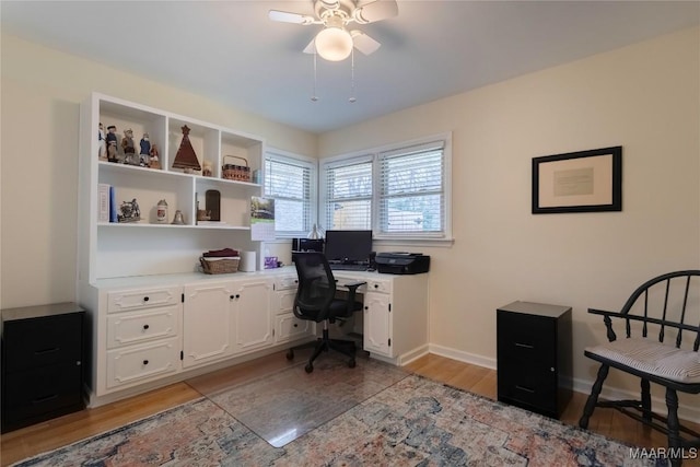 office area with a ceiling fan, light wood-type flooring, and baseboards