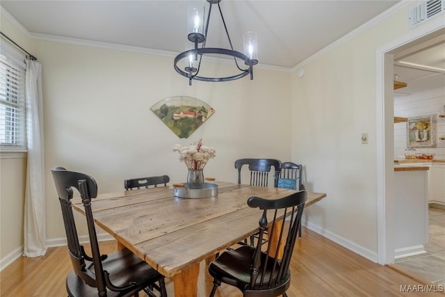 dining area featuring ornamental molding, light wood-type flooring, and visible vents