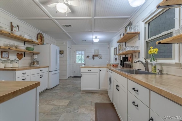 kitchen featuring butcher block countertops, a sink, white cabinets, open shelves, and washer / dryer