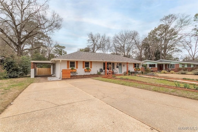 ranch-style home featuring concrete driveway, a front lawn, a porch, and an attached carport