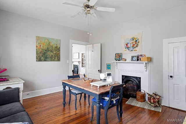 office area with a fireplace with flush hearth, baseboards, hardwood / wood-style floors, and a ceiling fan