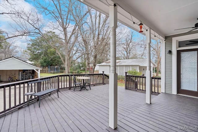 wooden deck with a trampoline and a ceiling fan