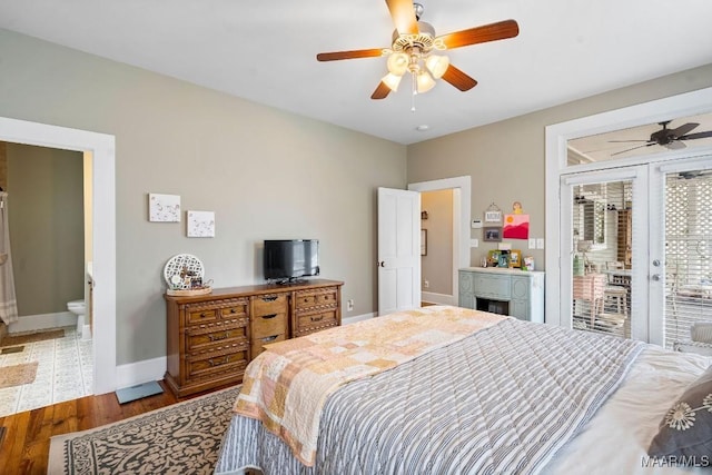 bedroom with wood finished floors, a ceiling fan, baseboards, access to exterior, and ensuite bath