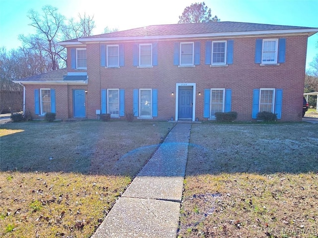 colonial home featuring a front lawn and brick siding