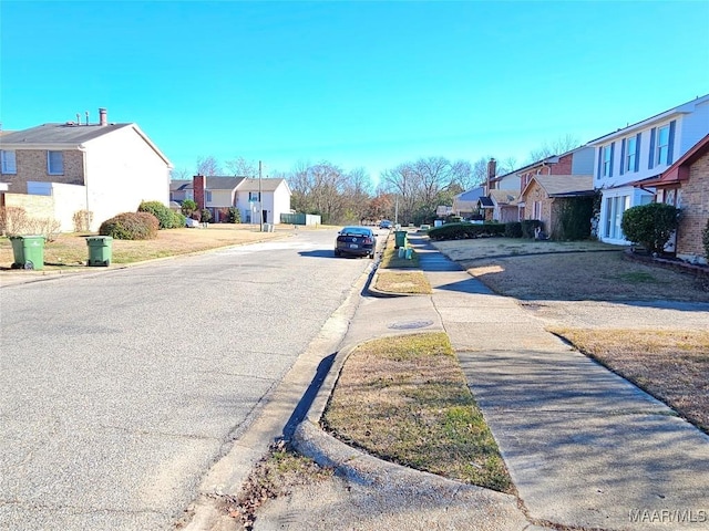 view of road with a residential view, curbs, and sidewalks