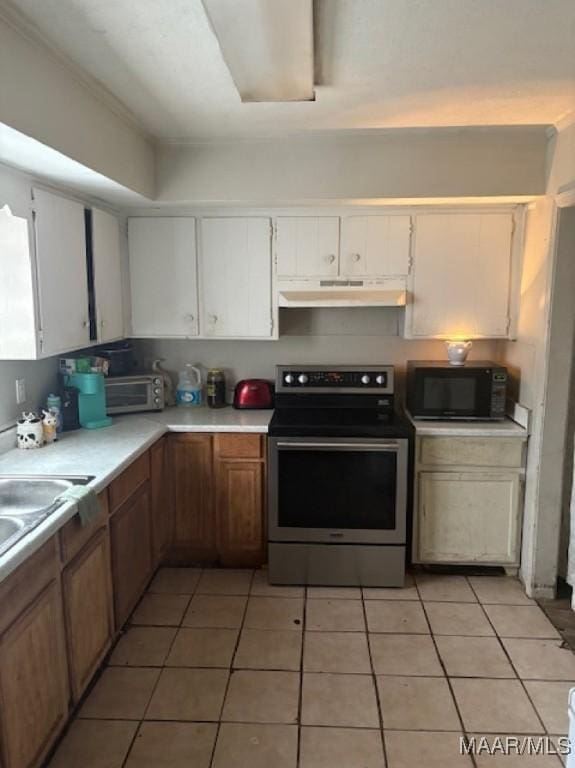 kitchen with black microwave, stainless steel electric range oven, light countertops, under cabinet range hood, and white cabinetry