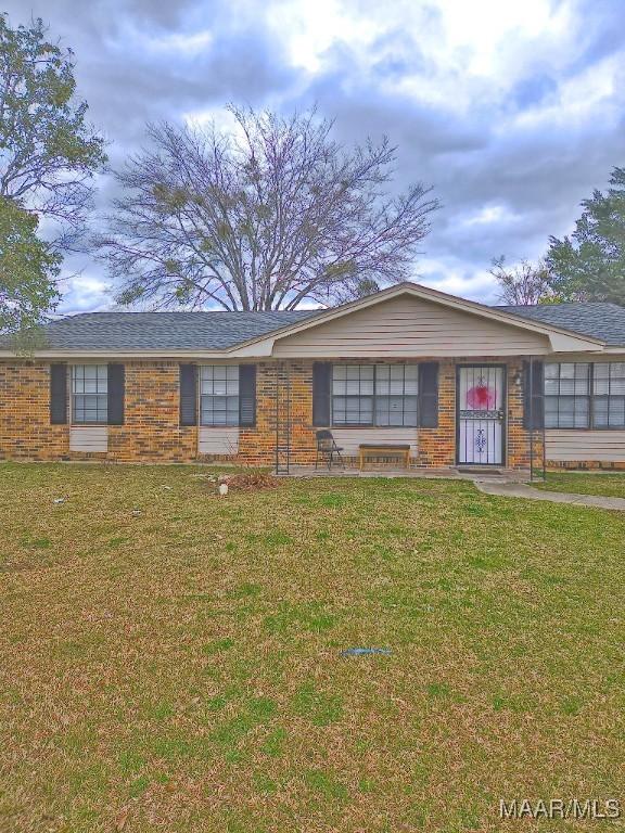 single story home featuring brick siding and a front lawn