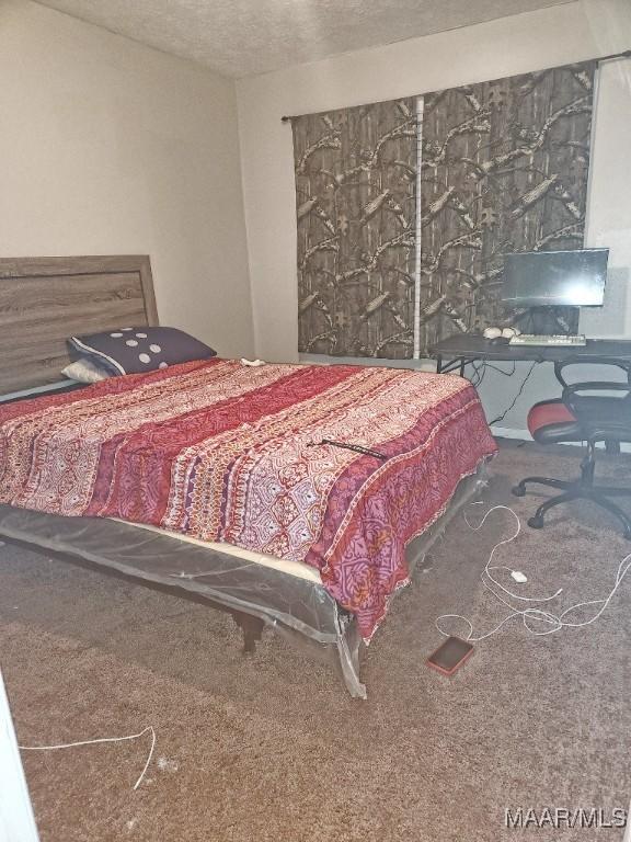 carpeted bedroom featuring a textured ceiling