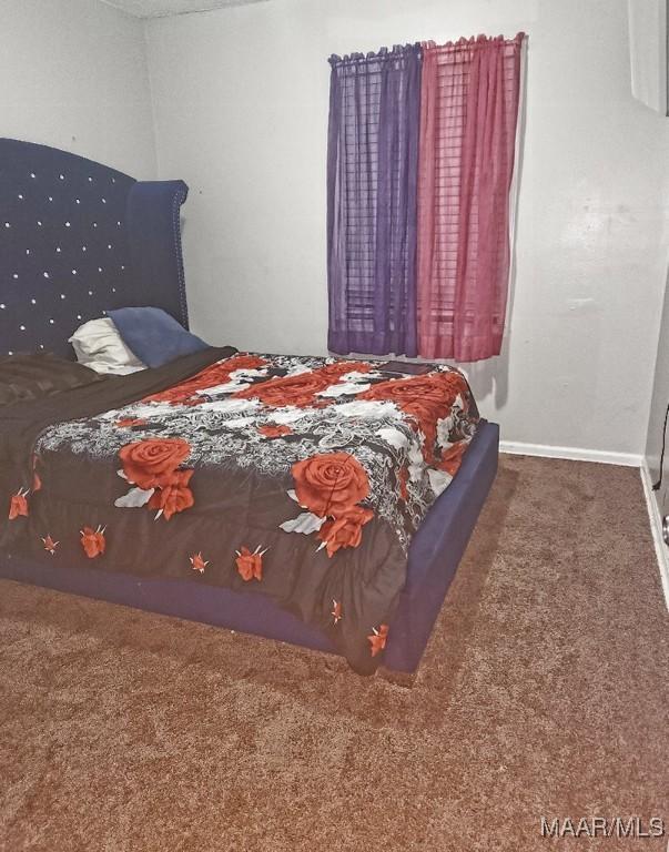 bedroom featuring carpet and baseboards