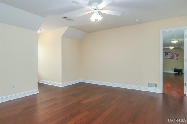 additional living space with dark wood-type flooring, a ceiling fan, visible vents, and baseboards