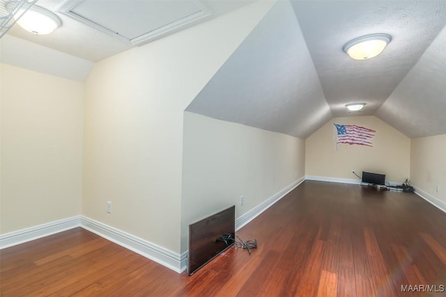 additional living space featuring vaulted ceiling, wood finished floors, and baseboards