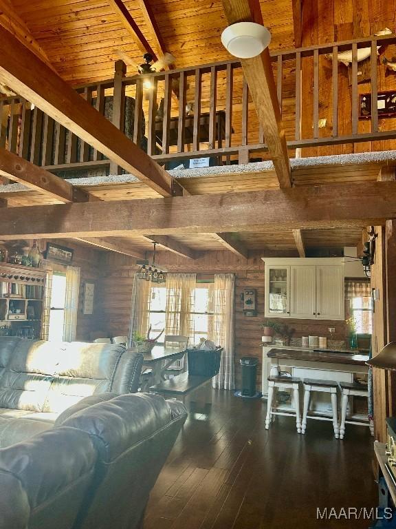 living area featuring beamed ceiling, wooden ceiling, and dark wood finished floors