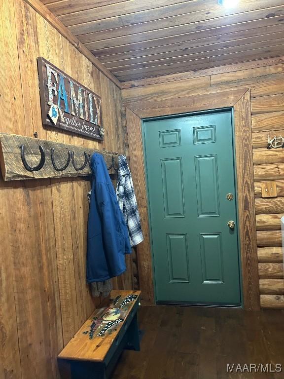 interior space with wooden ceiling, wood finished floors, and log walls