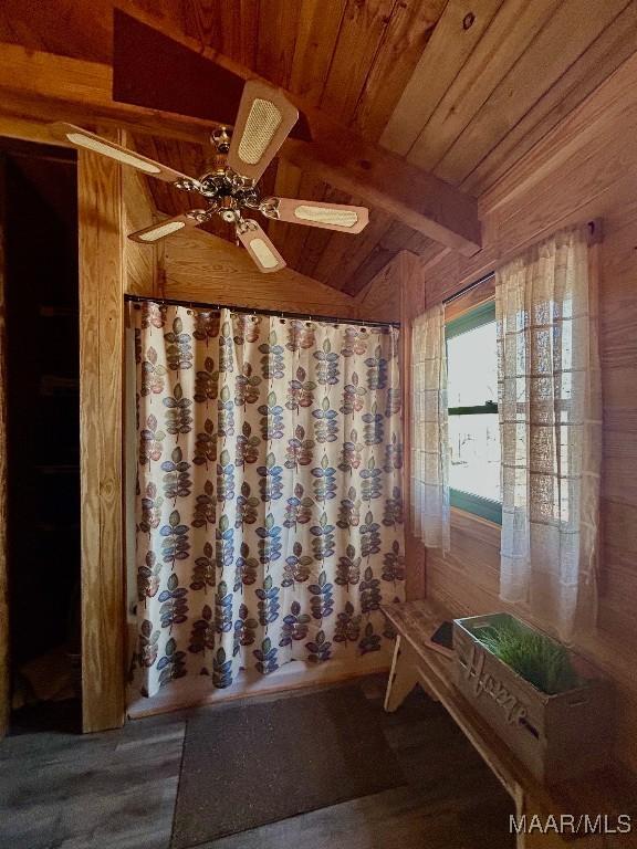 interior space featuring lofted ceiling with beams, wood ceiling, and a ceiling fan