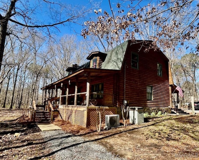 view of side of home featuring a shingled roof, central AC, and a gambrel roof