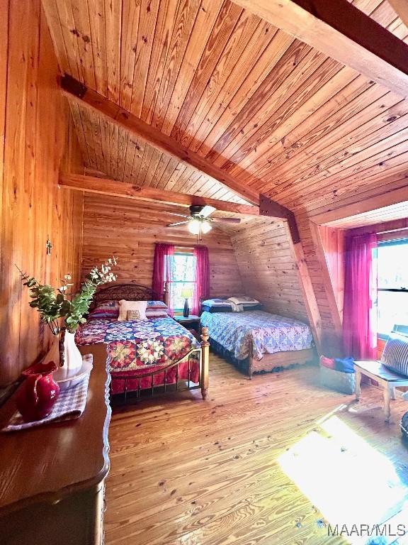 bedroom featuring wood ceiling, vaulted ceiling with beams, wooden walls, and hardwood / wood-style floors