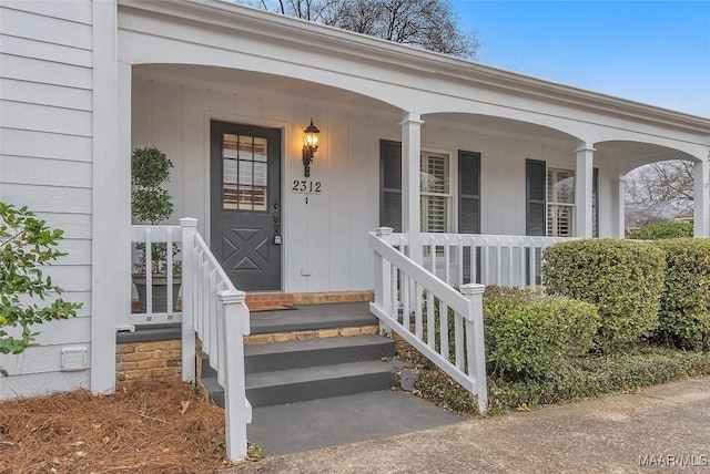 view of exterior entry featuring covered porch