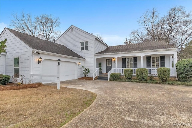 view of front of property with concrete driveway, a chimney, roof with shingles, an attached garage, and covered porch