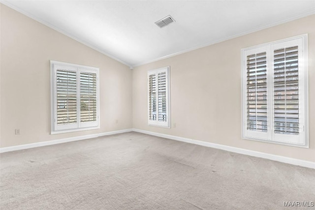 carpeted spare room featuring vaulted ceiling, baseboards, visible vents, and a healthy amount of sunlight