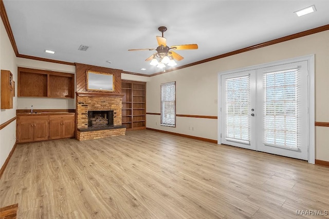 unfurnished living room with a fireplace, visible vents, baseboards, ornamental molding, and light wood finished floors