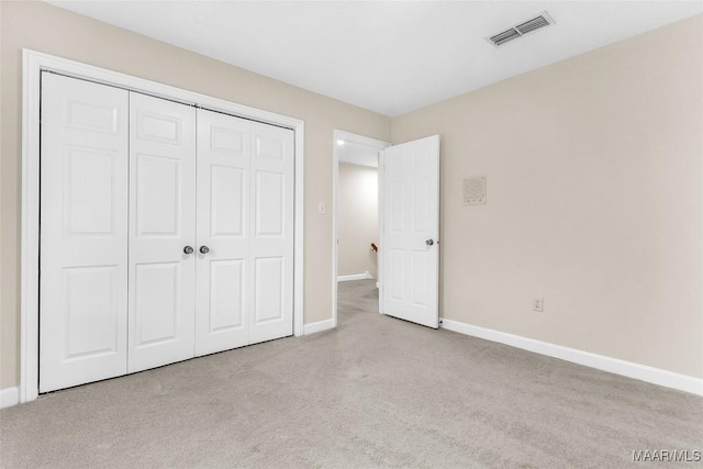 unfurnished bedroom with baseboards, visible vents, a closet, and carpet flooring