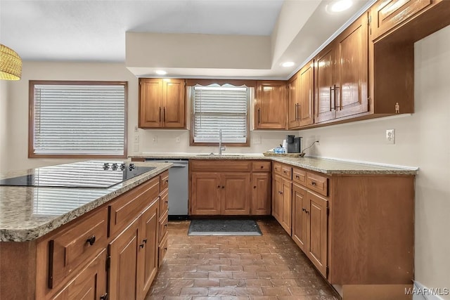 kitchen with dishwasher, a sink, black electric cooktop, and brown cabinets