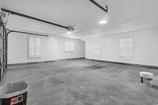 garage with a garage door opener and baseboards