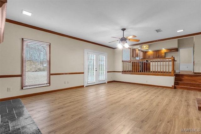 unfurnished living room with french doors, visible vents, light wood-style floors, ornamental molding, and baseboards