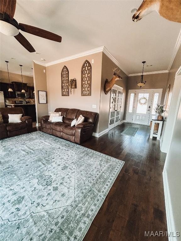 living room with dark wood-style floors, ornamental molding, baseboards, and ceiling fan