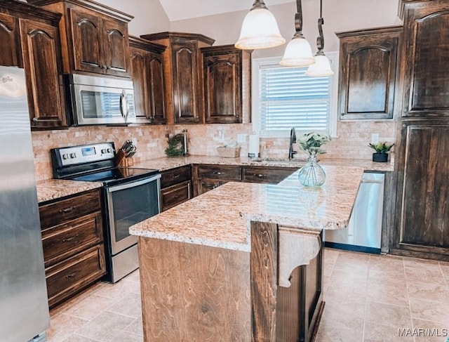 kitchen featuring appliances with stainless steel finishes, dark brown cabinetry, light stone counters, and tasteful backsplash